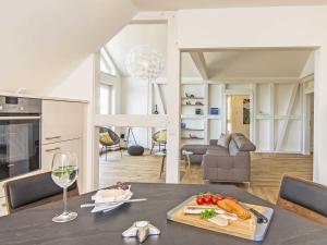 cocina y sala de estar con mesa y copa de vino en Auszeit Luxusappartment mit Meerblick und Infrarot Kabine, en Sassnitz