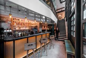 香港奥华·时尚精品酒店 - 中环的餐厅里的酒吧，有椅子和柜台