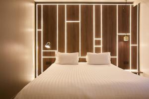 - une chambre avec un grand lit et 2 oreillers blancs dans l'établissement Best Western Plus Paris Meudon Ermitage, à Meudon