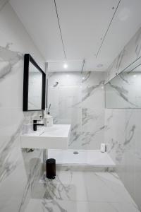 a white bathroom with a sink and a mirror at Best Western Plus Paris Meudon Ermitage in Meudon