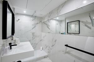 a white bathroom with a sink and a mirror at Best Western Plus Paris Meudon Ermitage in Meudon