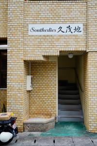 a brick building with a staircase and a sign on it at Naha Southerlies Condominium Kumoji in Makishimachi