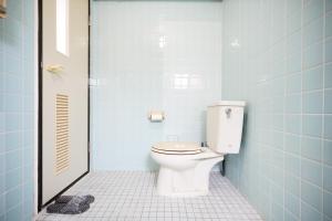 a bathroom with a toilet in a blue tiled bathroom at Naha Southerlies Condominium Kumoji in Makishimachi
