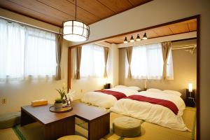 a bedroom with two beds in a room with windows at Naha Southerlies Condominium Kumoji in Makishimachi
