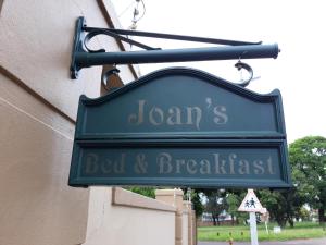 a sign for a bed and breakfast hanging on a building at Joan's Bed and Breakfast in Durban