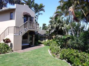a house with a balcony and palm trees at Joan's Bed and Breakfast in Durban