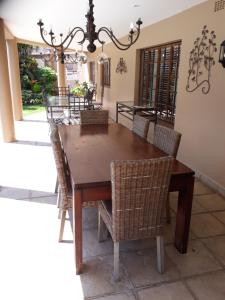 a dining room with a wooden table and chairs at Joan's Bed and Breakfast in Durban