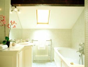 Baño blanco con bañera y lavamanos en Dunbrody Country House Hotel, en Arthurstown