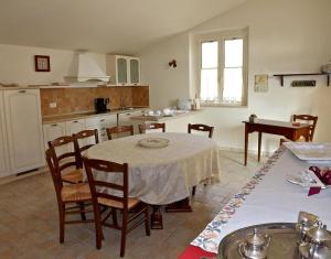 cocina con mesa, sillas, mesa y mesa en il Piccolo Melograno, en Montecosaro