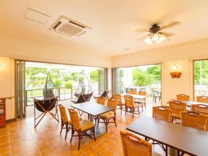 jadalnia ze stołami, krzesłami i oknami w obiekcie Sun Green Resort Hotel Ishigaki w mieście Ishigaki