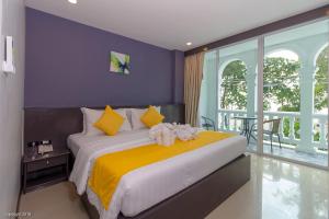فندق مودرن ليفينغ في شاطيء باتونغ: غرفة نوم بسرير كبير وبجدران صفراء وارجوانية