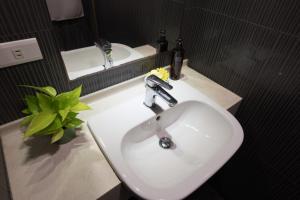 un lavandino bianco nel bagno con rubinetto e specchio di Banff-Penghu B&B a Magong