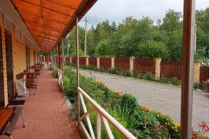 a patio with tables and benches and a garden at Baza otdikha Rozovaya Dacha in Kutuzovskoye