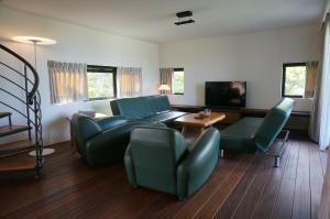 卑南鄉的住宿－椰子海岸民宿 ，客厅配有沙发、椅子和电视