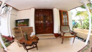 una puerta delantera de una casa con una mesa y una silla en Suriya Ocean Villa, en Wadduwa