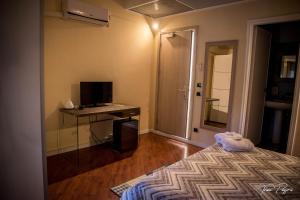 una camera con letto e scrivania con TV di Hotel Lonatino a Lonato