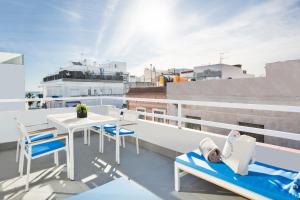 een balkon met een tafel en stoelen op een dak bij Sitges Group Blue&White in Sitges