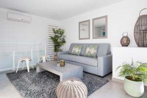 een woonkamer met een bank en een tafel bij Sitges Group Blue&White in Sitges