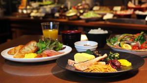 una mesa de madera con platos de comida. en Hotel Keihan Tokyo Yotsuya, en Tokio