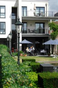 a group of people sitting under umbrellas outside a building at Hotel Schepers in Gronau