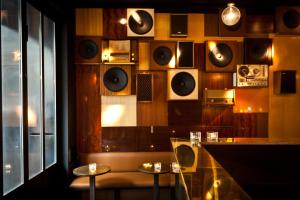 une salle avec un bar avec des tables et des haut-parleurs sur le mur dans l'établissement HotelO Kathedral, à Anvers