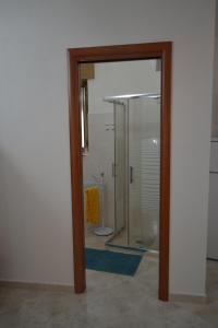 eine Glastür, die zu einem Bad mit einer Dusche führt. in der Unterkunft La Tana di Cruk in San Vito dei Normanni
