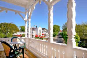biała altana ze stołem i krzesłami na ganku w obiekcie Hotel Garni Getreuer Eckart w mieście Binz