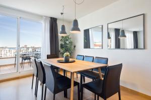 a dining room with a wooden table and black chairs at Sitges Group Soul in Sitges