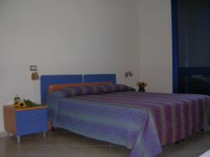 トッレ・ラピッロにあるB&B Gioiello del Mareのベッドルーム(青いベッド1台、青いナイトスタンド付)