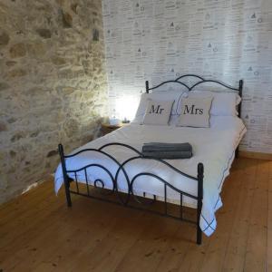 - un lit avec des draps et des oreillers blancs dans une chambre dans l'établissement Le COSY, à Saint-Yrieix-la-Perche