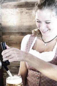 una mujer mirando su celular mientras hacía una bebida en Wies'n Camp en Múnich