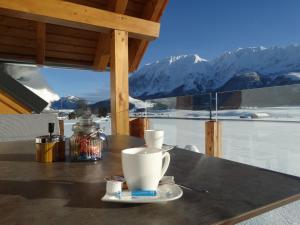 a table with a cup of coffee and a view of mountains at Alpenapartments Steiermark in Bad Mitterndorf