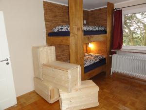 a wooden bunk bed sitting next to a wooden door at Peanuts Hostel & Meer in Surendorf