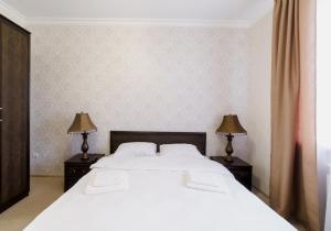 ニジニ・ノヴゴロドにあるHotel Balmontのベッドルーム(大きな白いベッド1台、ランプ2つ付)