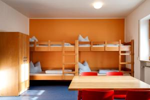 雷根斯堡的住宿－雷根斯堡青年旅舍，客房设有双层床和桌椅。