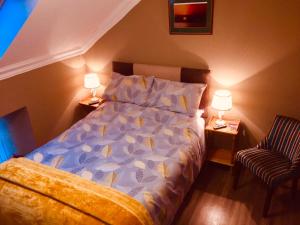 1 dormitorio con 1 cama, 2 lámparas y 1 silla en Pisgah Guesthouse, en Blaenau Ffestiniog