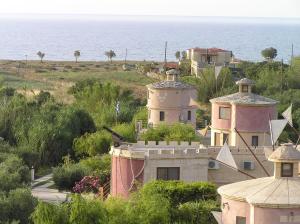 een groep gebouwen op een heuvel naast de oceaan bij Anemomili Village in Kissamos