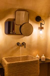 baño con lavabo con espejo y luces en Reflection Cave House, en Pirgos