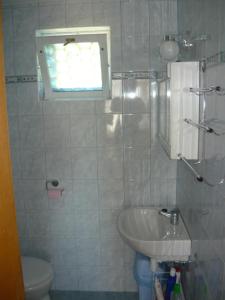 La salle de bains est pourvue d'un lavabo, de toilettes et d'une fenêtre. dans l'établissement Judit Vendégház a Balatonnál, à Vonyarcvashegy