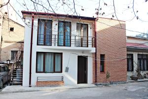 a brick house with a black door and a balcony at Maria's homestay in Tbilisi City