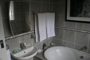 a bathroom with a sink and a toilet and a tub at Pebbles and Shells in Chintsa