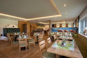 a restaurant with wooden tables and chairs and a kitchen at Frühstückspension Ochnerbauer in Kindberg