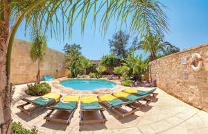 a patio with a table and chairs and a pool at Villa Sky in Żejtun