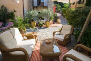 een patio met rieten stoelen en een salontafel bij Villa I Poggioli in Bocca di Magra