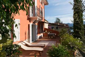een patio van een huis met stoelen en een balkon bij Villa I Poggioli in Bocca di Magra