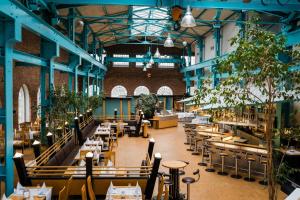 a restaurant with tables and chairs in a building at Hotel Alte Werft in Papenburg