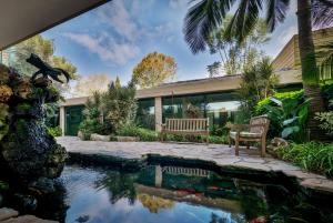 a house with a pool with two benches and a bird statue at Carmel Forest by Isrotel Exclusive in Bet Oren