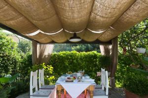 una mesa y sillas sentadas bajo una pérgola en Villa I Poggioli, en Bocca di Magra