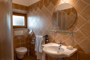 a bathroom with a sink and a toilet and a mirror at Villa La Malva in Poggio alla Malva