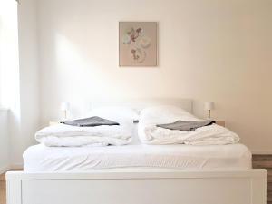 un letto bianco con due cuscini sopra di cozy family apartment Ospelgasse a Vienna